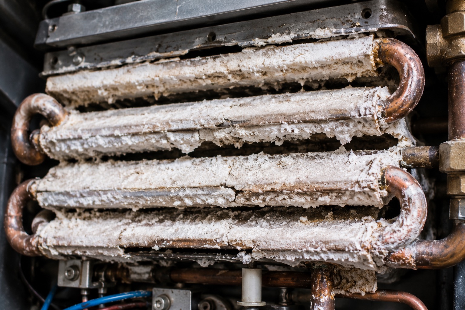 Scale buildup inside a tankless water heater heat exchanger from hard water — True Grit Plumbing Georgia